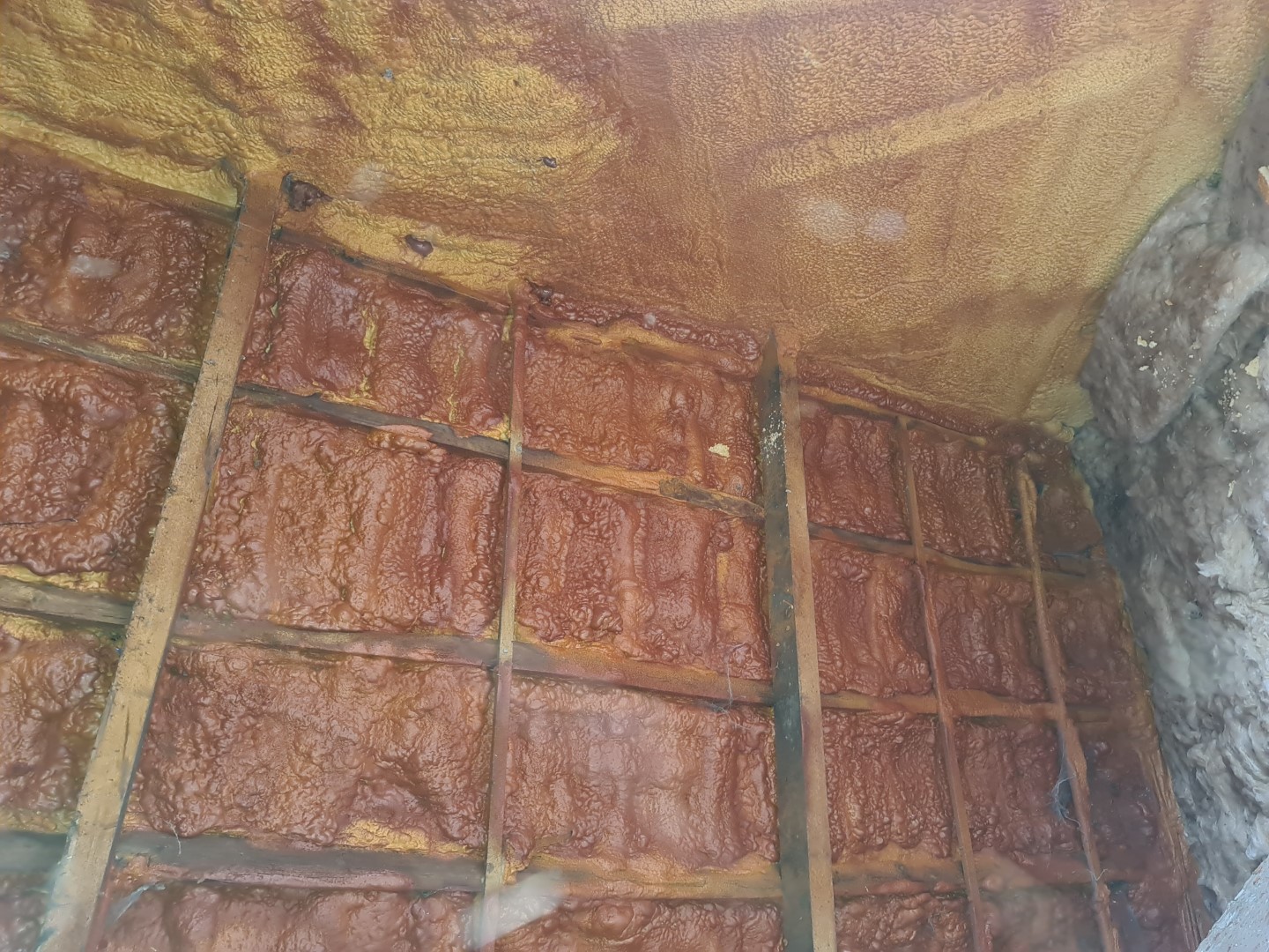 spray foam insulation covering beams and stonework